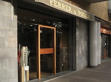 Entrada de la tienda Ferrer & Ponce, con puerta de madera y rótulo sobre la fachada.